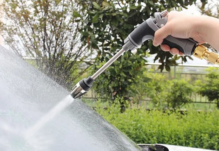 Power washer attachment cleaning an outdoor surface